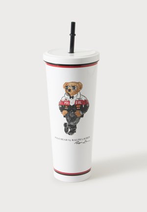 Gobelet blanc avec couvercle et paille noire, avec un ours en lunettes de soleil portant une veste et un jean, étiqueté Polo Bear par Ralph Lauren.