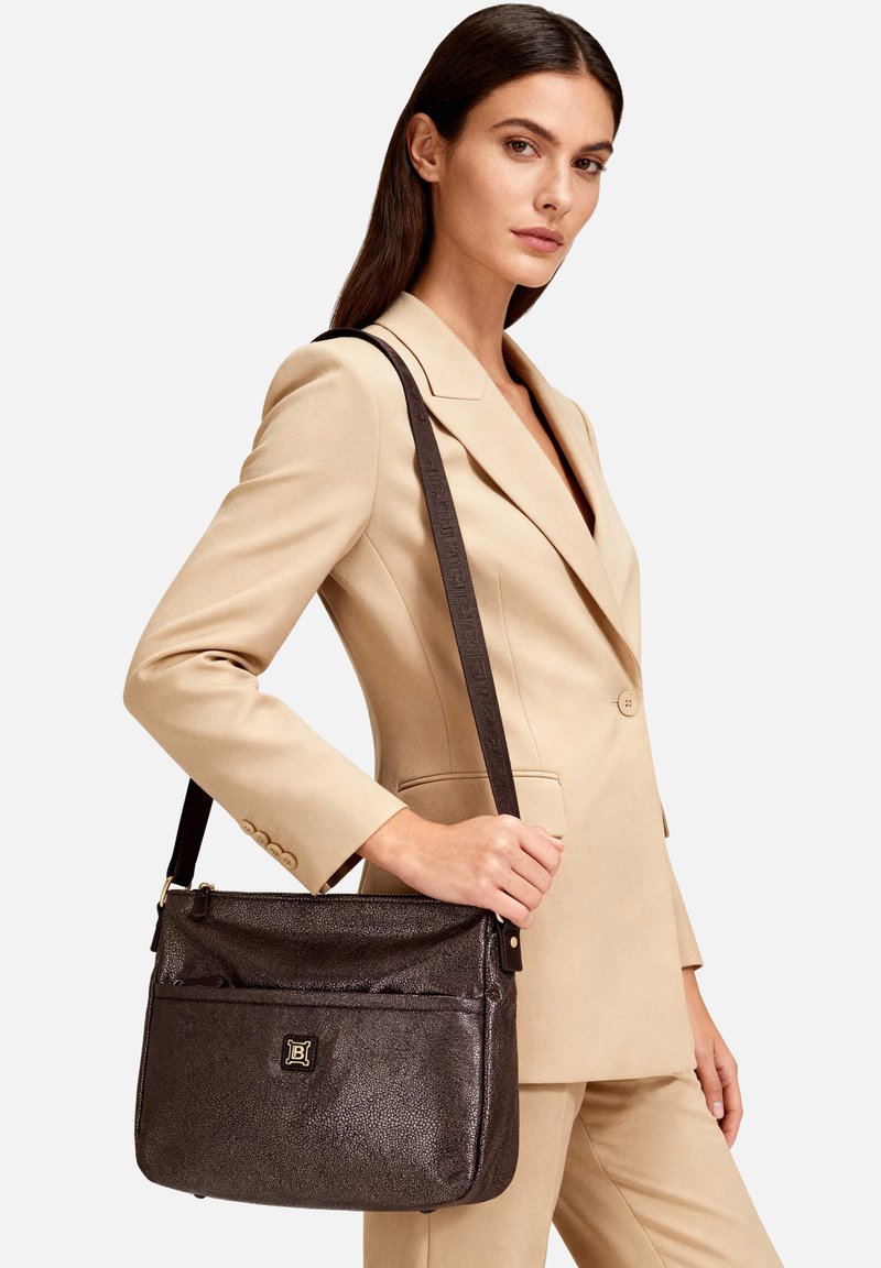 Borsa a tracolla in pelle marrone con finitura testurizzata, dotata di chiusura superiore con cerniera, tracolla regolabile e tasca frontale con dettaglio logo.