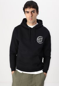 Felpa con cappuccio nera realizzata in cotone, con tasca frontale, caratterizzata da un logo circolare bianco ricamato sul petto.