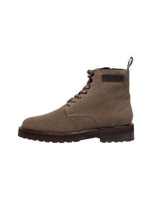 Brown suede ankle boots featuring a round toe, lace-up front, and a small heel. Includes a pull tab and a logo patch on the side.