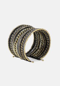 Brățară din mărgele negre și aurii, cu un design ondulat, având mărimi și texturi de mărgele alternante, și accente metalice mici pe margini.