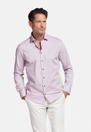 Chemise boutonnière rose clair en tissu texturé, dotée d'une coupe ajustée, de manches longues et de boutons sombres contrastants.