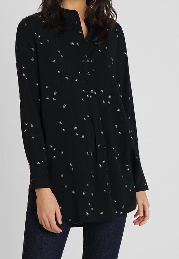 Chemise noire boutonnée ornée d'une broderie étoilée argentée, manches longues, encolure sans col et coupe décontractée.