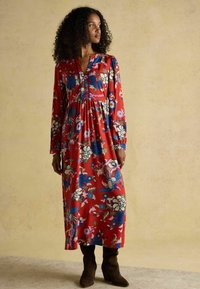 Rotes Maxikleid mit langen Ärmeln, ausgestattet mit einem V-Ausschnitt und tailliertem Bund, verziert mit blauen, rosa und cremefarbenen Blumenmustern.