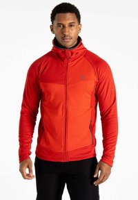 Rote ZIP-Jacke mit hohem Kragen, strukturierten oberen Panels und zwei Seitentaschen. Mit einem Logo auf der Brust und Akzenten an den Ärmeln.