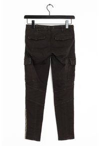 Černé cargo kalhoty s přiléhavým střihem, které mají boční kapsy, strukturovaný povrch a zipy na kotnících. Vypadají lehce a odolně.