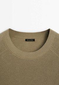 Kaki stickad tröja med rund ribbad halsringning, med en texturerad yta och en liten svart "Mango" etikett vid kragen.