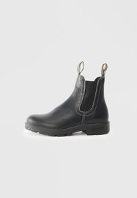 Bottines Chelsea noires en cuir avec des panneaux latéraux en élastique, finition texturée, languettes de tirage et semelle en caoutchouc solide. Présente des détails de couture contrastante.
