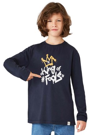 Marineblaues Langarm-T-Shirt mit einem grafischen Design, das eine gelbe Krone und den Text "König der Narren" in Weiß zeigt. Aus weichem Baumwollmaterial.