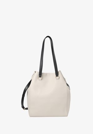 Bēša ādas totē soma ar garām melnām rokturiem un regulējamu melnu plecu jostu, vienkāršs dizains uz balta fona.