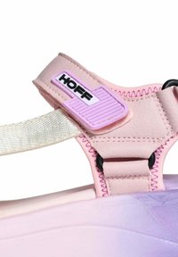 Sandalia rosa con un upper texturizado, con un logo HOFF morado, tira trenzada y una suela en degradado que transiciona de rosa a morado.