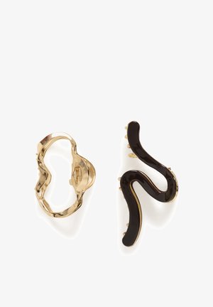 Zwei dekorative Haarspangen, eine goldfarben mit wellenförmiger Umrandung und eine schwarze Emaille mit gebogener, abstrakter Form.