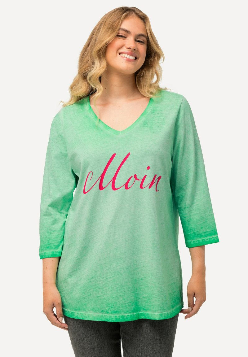 Grüner V-Ausschnitt-Tunika mit 3/4-Ärmeln, die ein Farbverlaufdesign zeigt, das von hellgrün zu dunkelgrün übergeht, und dem Wort "Moin" in pinker Schreibschrift.