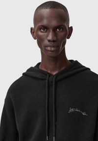 Zwarte hoodie van zacht stof, voorzien van een trekkoord en een subtiele "Allsaints" borduring op de borst. Soepele textuur.