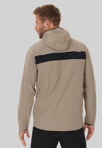 Hellbeige, hüftlange Jacke mit Kapuze, die einen schwarzen horizontalen Streifen über den Rücken hat, mit langen Ärmeln und einer glatten, flexiblen Stofftextur.
