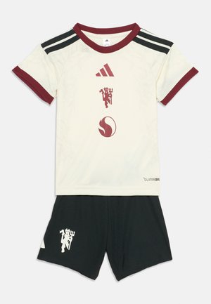 Weißes Fußballtrikot mit kurzen Ärmeln, bordeauxfarbenem Kragen und Bündchen, schwarzen Shorts, Adidas-Logo und einem roten Teufel-Emblem auf beiden Teilen.