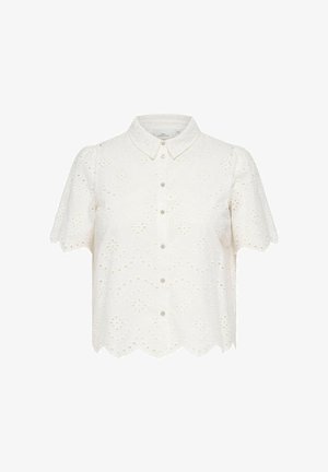 Balta trumpomis rankovėmis palaidinė su sagomis, akių siuvinėjimu, bangelėmis apjuostu kraštu ir smailėjančiais atlapais, pateikta priešais vientisą foną.