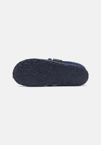 Dark blue footwear with a textured rubber sole, featuring a wavy pattern. The brand label "NANGA" is visible on the side.
