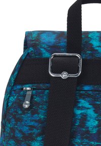 Zaino multicolore con un motivo blu e nero, materiale in tessuto, spallacci in tela nera e un dettaglio in metallo argentato.