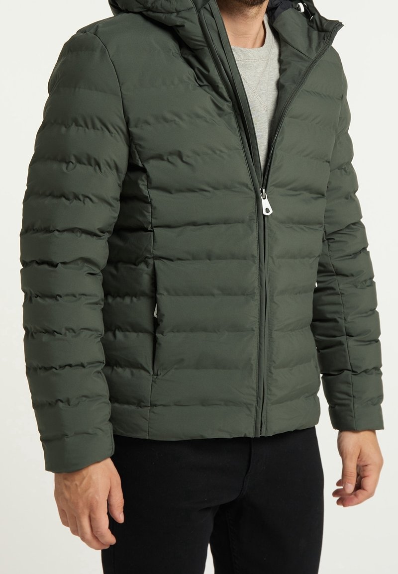 Veste matelassée verte avec fermeture éclair à l'avant et capuche. Présente une texture matelassée horizontale et des poignets élastiques. Conception légère adaptée aux temps froids.