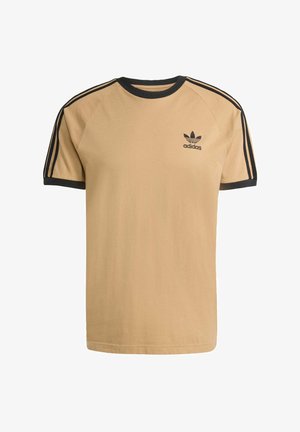 Beige katoenen t-shirt met een zwarte ribgebreide ronde hals en mouwranden. Bevat drie zwarte zijstrepen en een klein zwart "adidas" logo.