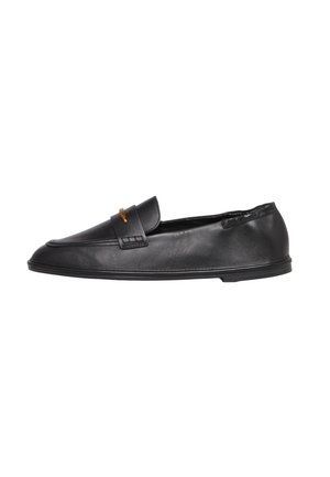Zwarte leren loafer met lage platte zool en een klein gouden accent op de band, ontworpen voor gemakkelijk slip-on comfort.