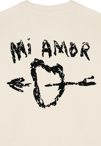 Felpa beige con un grande design grafico nero e il testo "Mi Amor" sopra un cuore trafitto da una freccia.
