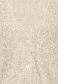 Cardigan en maille texturée de couleur crème douce avec deux boutons semblables à des perles à l'avant et un col en V.
