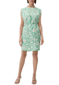 Abito verde a fiori con una silhouette rilassata, maniche a cappuccio, vita aderente e tessuto morbido. Abbinato a sandali nudi.