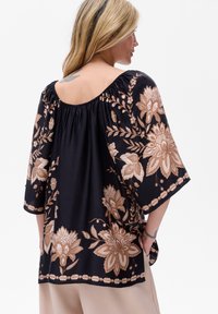 Czarna bluzka z kwiecistym haftem w odcieniach złota i beżu. Luźny krój, dekolt w łódkę, oraz rękawy o długości do łokcia z marszczeniami.