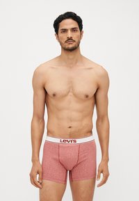 Crvene pamučne bokserice s bijelim pojasom na kojem se nalazi Levi's logo u crvenoj boji. Prikladan dizajn s prošivenim šavovima i glatkom teksturom.