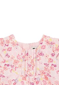 Robe florale en coton léger. Elle présente une base rose avec des fleurs multicolores, un col plissé et une fermeture à boutons au dos.