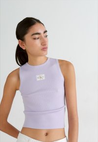 Lavanda, rebrasta, bez rukava, kratki top s okruglim izrezom i logo aplikacijom na prsima, glatka tkanina, prilagođeni dizajn.