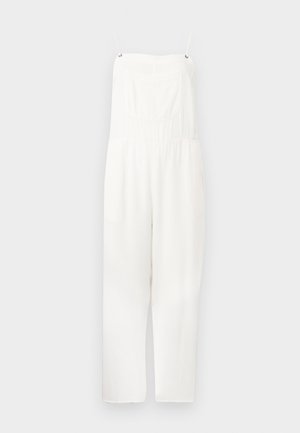 Balta berankovė kombinezono su plonomis petnešėlėmis, kvadratine iškirpte, priekinė krūtinės kišenė ir plačios kelnės.