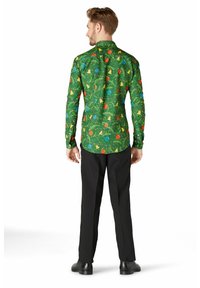 Zala garā piedurkņu krekls ar svinīgu daudzkrāsainu rotājumu un lapotnes printu; apvienots ar melnām biksēm un melniem apaviem.