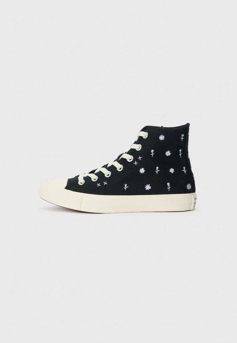 Sneakers alte nere con ricami floreali bianchi, suola in gomma crema e occhielli. Presentano una tomaia in tessuto testurizzato e chiusura con lacci.