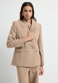 Beige Doppelreiher-Blazer mit goldenen Knöpfen, Reverskragen und Seitentaschen. Strukturierter Stoff, taillierte Passform und elegantes, strukturiertes Design.