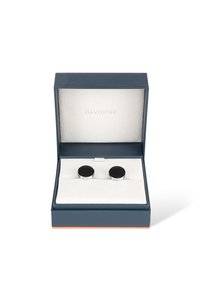 Silver-tone cufflinks with black circular centers, displayed on a soft white cushion inside a navy blue box, featuring a subtle textured finish.