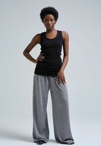 Svart ribbad linne kombinerat med lösa, ljusgrå sweats. Outfiten har en avslappnad passform och mjukt, slätt tyg.