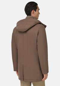 Veste à capuche marron au toucher lisse, dotée d'un col rabattu, de poches latérales et d'une coupe droite. Conçue pour la chaleur et le confort.