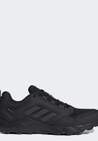 Scarpa da trail running Adidas Terrex nera con tomaia in Gore-Tex, suola robusta e chiusura con lacci, mostrata di profilo.