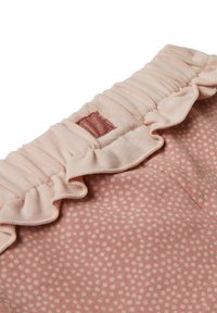 Lichtroze stof met witte stippen, voorzien van een rijgbare elastische tailleband en een klein gestikt rechthoekig label.