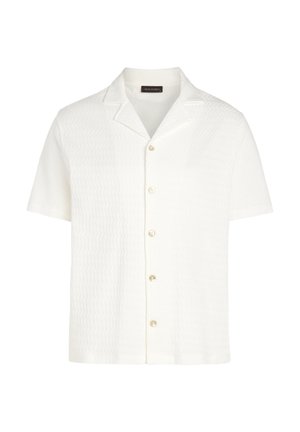 Kortærmet hvid skjorte lavet af tekstureret stof med en klippet krave og knaplukning, forsynet med fem perle-lignende knapper.
