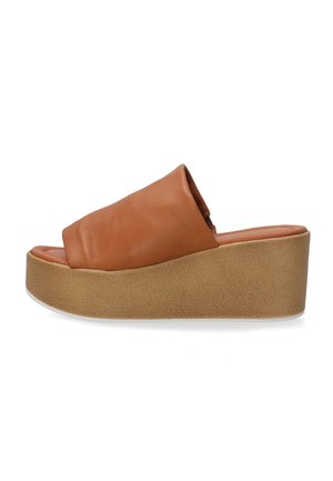 Læder slidesandal i tan, med en bred rem, blød tekstur og en kontrasterende tan platform med en struktureret finish.