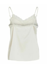 Camisole blanche à fines bretelles réglables, ornée d'une bordure en dentelle le long du décolleté et de l'ourlet ; confectionnée dans un tissu lisse et léger.