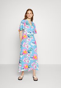 Vestido maxi floral com um fundo azul claro, adornado por flores vibrantes em rosa e amarelo, mangas curtas e um fecho frontal com botões.