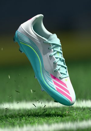 Ανοιχτό μπλε και λευκό ποδοσφαιρικό παπούτσι με ροζ λεπτομέρειες, με αεροδυναμικό σχέδιο, κλείσιμο με κορδόνια και υφή επιφάνειας. Ιδανικό για γήπεδα με χόρτο.