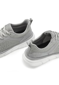 Graue Sportschuhe mit einem Mesh-Obermaterial, strukturierten Akzenten und einer weißen gepolsterten Sohle. Mit Schnürsenkeln und einem gepolsterten Schaft für zusätzlichen Komfort.