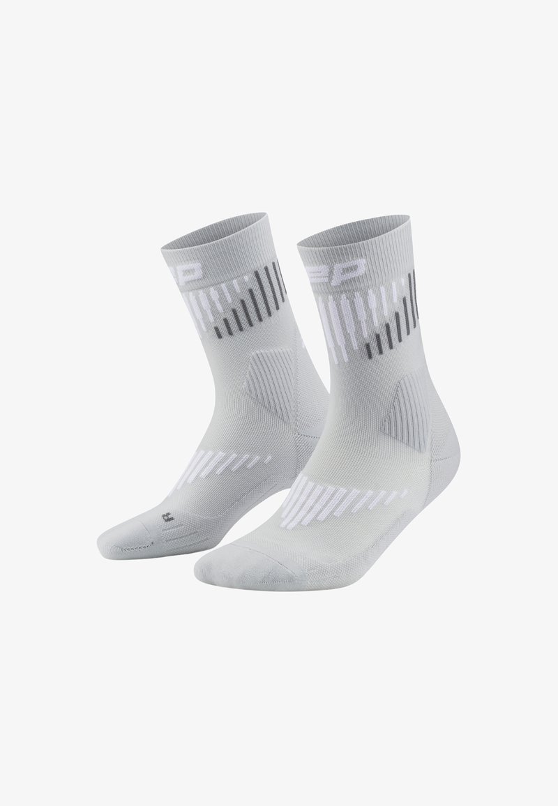 Calcetines deportivos de color gris claro con textura acanalada, acentos en blanco y negro, y patrones de rayas dinámicos en la parte superior.