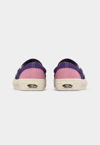 Ζευγάρι χαμηλών αθλητικών παπουτσιών Vans με μοβ καμβά και ροζ τακούνια από σουέτ, φαίνεται από πίσω σε λευκό φόντο.